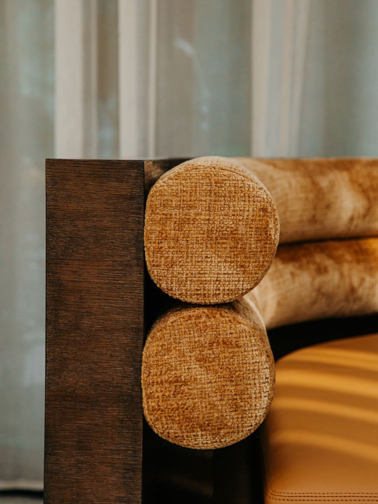 Höfðatorg — a bolster in Icelandic wool against the end of a stained timber bench.