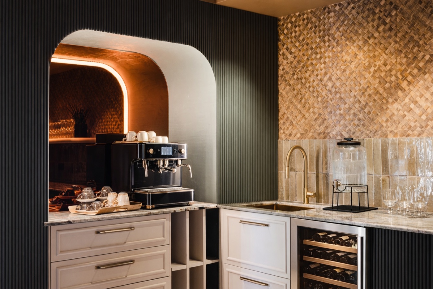 Reykjavík Residence — a compact bar with illuminated arched shelving and a tiled wall.