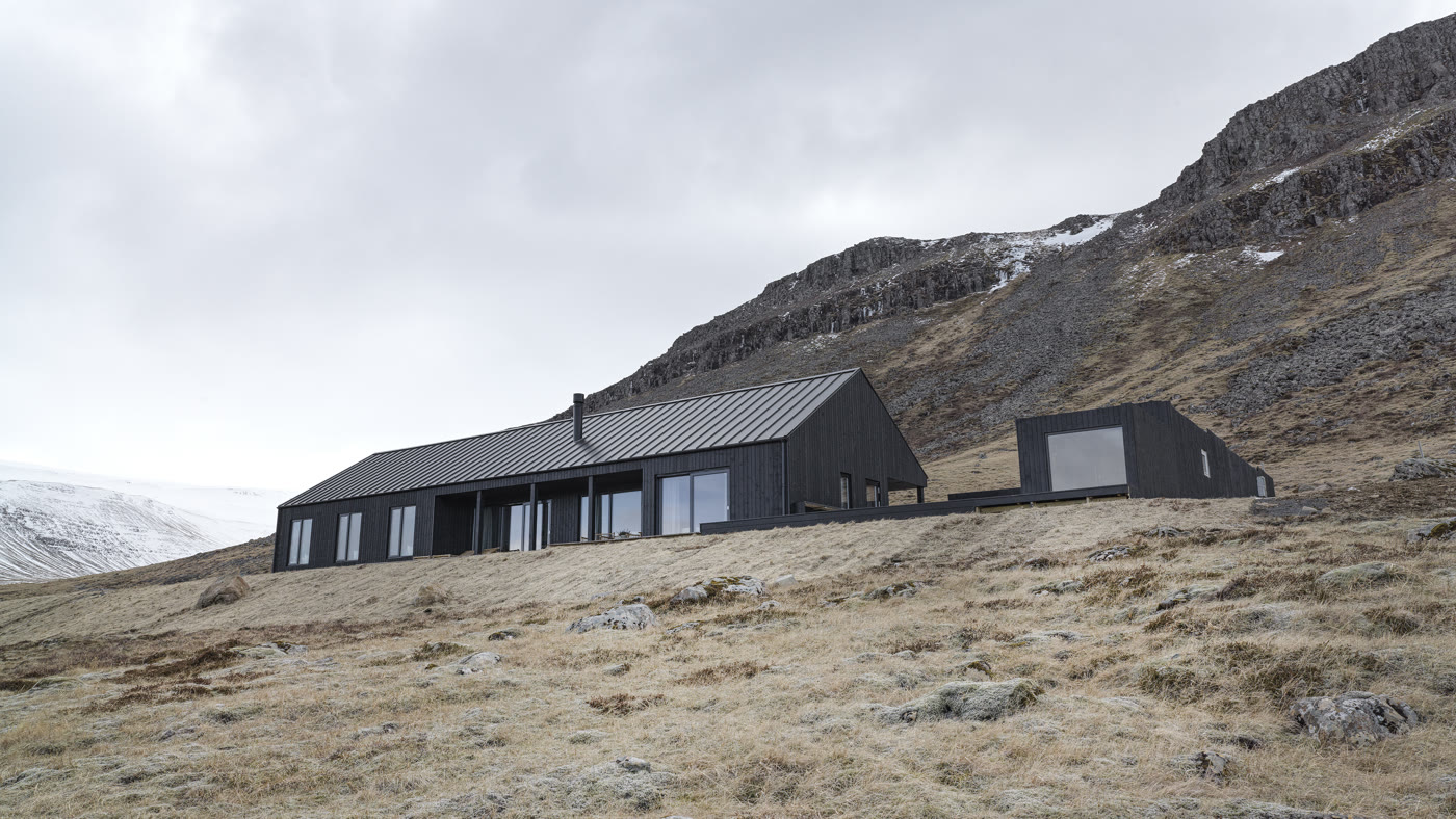 The Lake House at Meðalfellsvatn — black timber volumes low against the hillside.