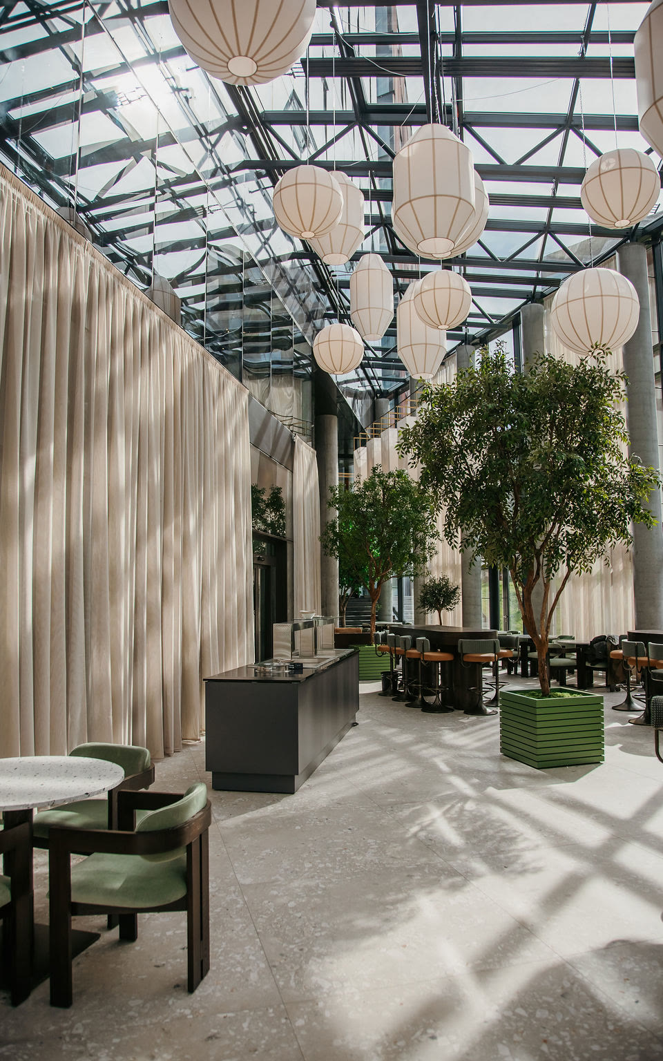 The atrium at Höfðatorg, paper lanterns and olive trees over the tables.